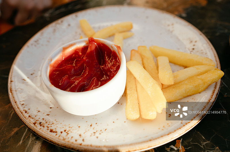美味的薯条配番茄酱，摆放在乡村风格的桌子上图片素材