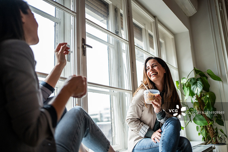 两位女商人在窗边休息聊天图片素材