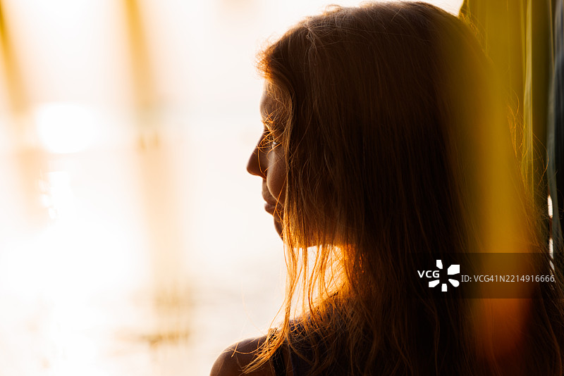 在辉煌的日落背景下，沉思的女性剪影图片素材