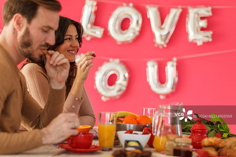 情侣在浪漫的背景下享受早餐。图片素材