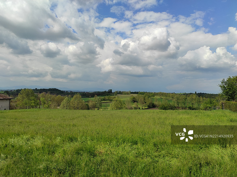 丘陵风景下的田野与天空相映成趣图片素材