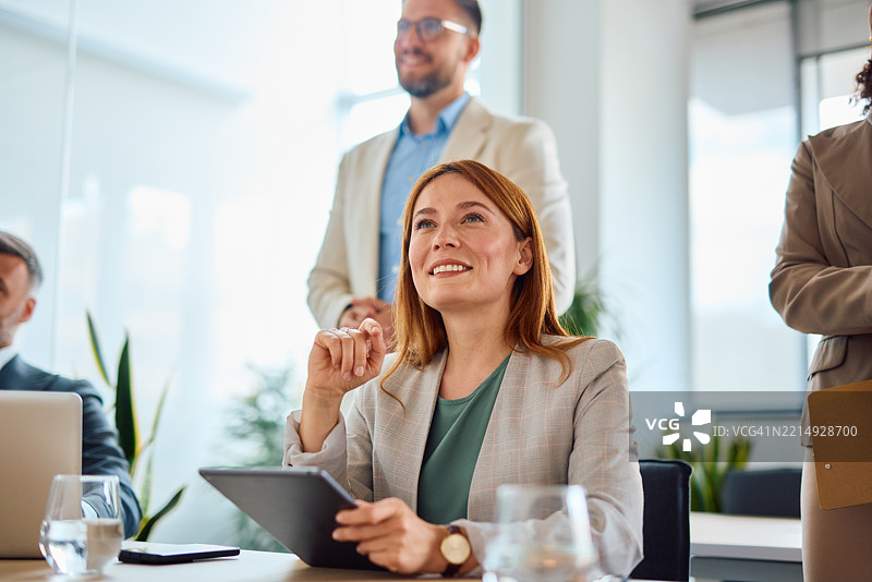 女商人在办公室使用平板电脑并参加会议图片素材