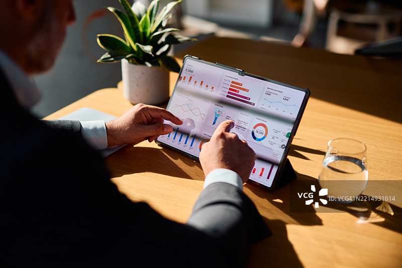 商人正在分析数字平板上的财务图表和图形图片素材