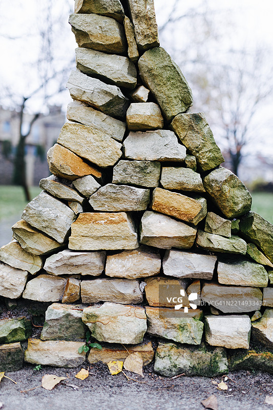 公园环境中的纹理石墙，背景是季节性树木图片素材