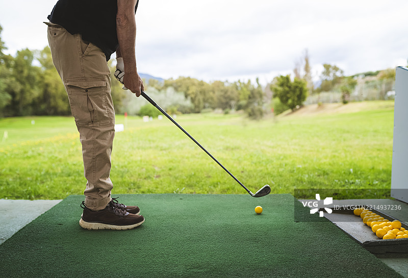 一名男子在高尔夫练习场击打球，男子在打高尔夫球图片素材