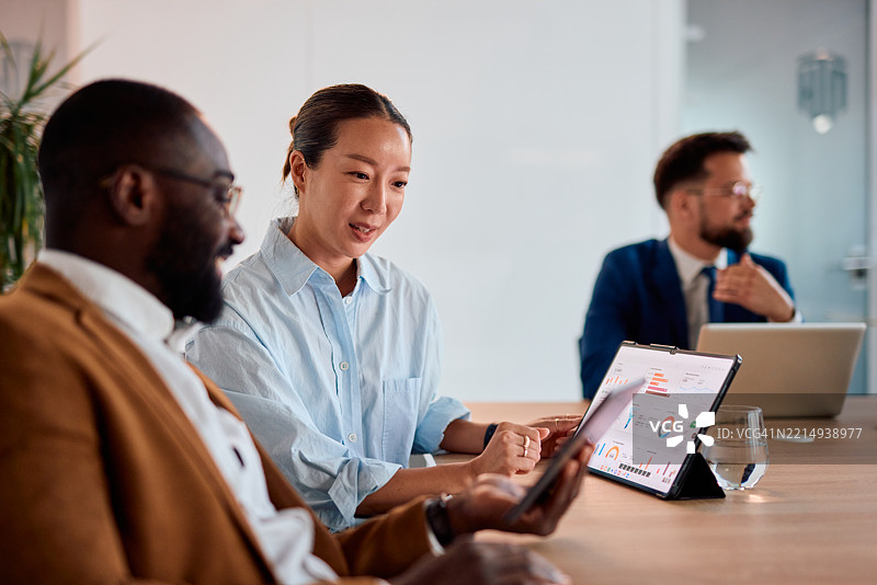 商务人士在会议中使用平板电脑分析财务数据图片素材