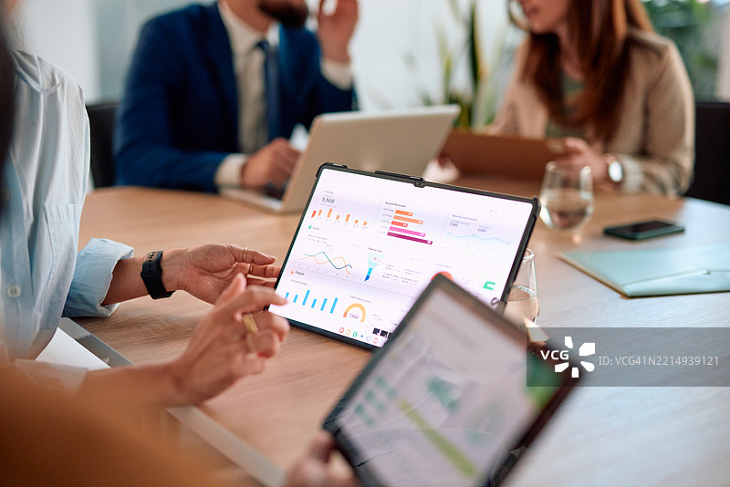 商务团队在会议中使用数字平板分析财务数据图片素材