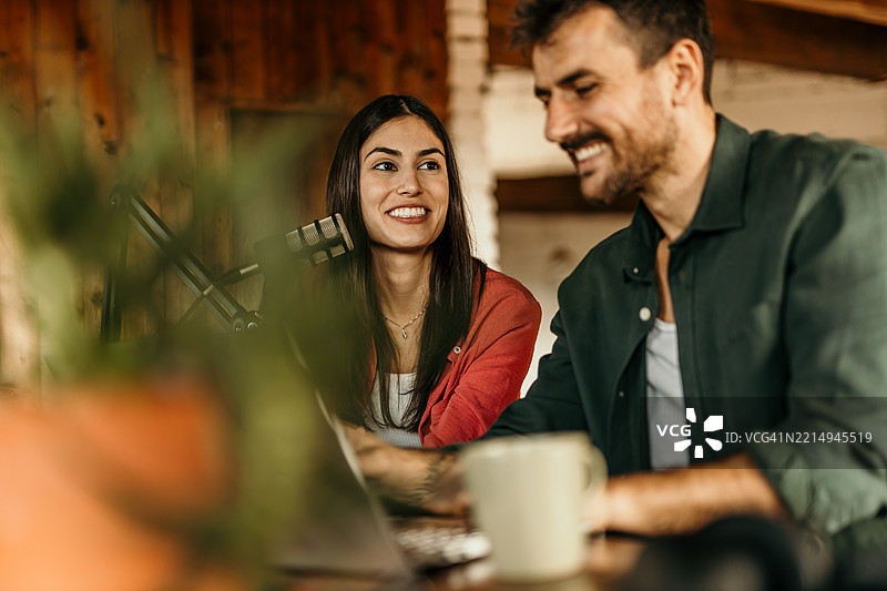 内容创作者在乡村风格的家庭工作室录制播客图片素材