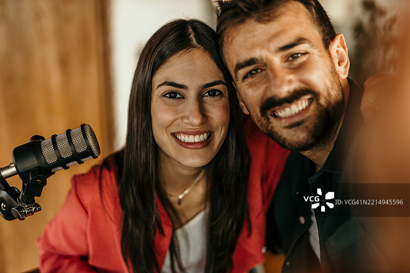 两位微笑的播客主持人在录音室录制节目图片素材