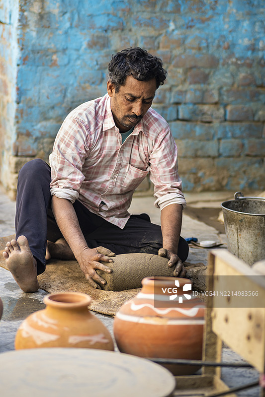 印度陶工正在揉捏泥土，为在陶轮上工作做准备。图片素材