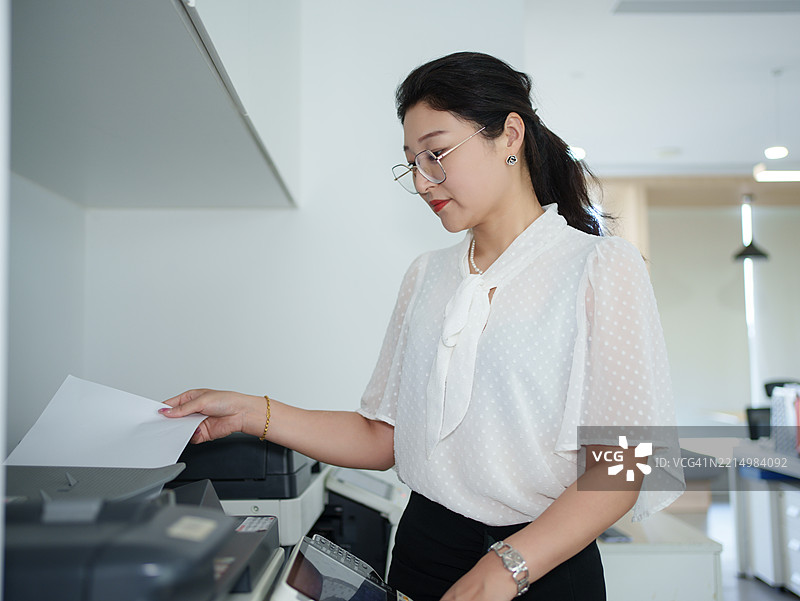 亚洲女性员工正在使用复印机图片素材