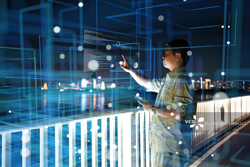 一名亚洲男子在夜间使用虚拟现实技术，人工智能图片素材