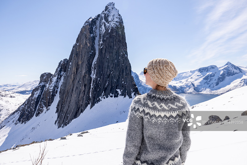 穿着冬季服装的女性欣赏雪山风景图片素材