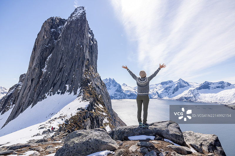 在山顶庆祝的旅行者，俯瞰风景如画的峡湾景色图片素材