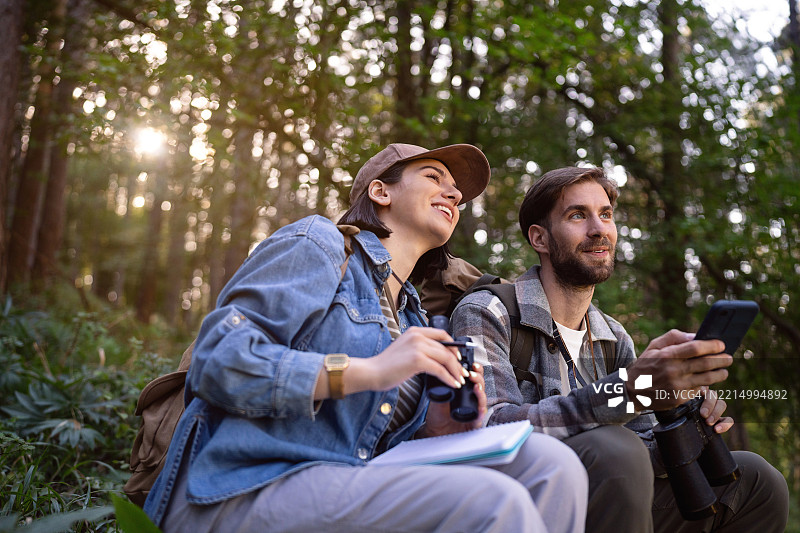 朋友们在阳光明媚的户外森林中观鸟图片素材
