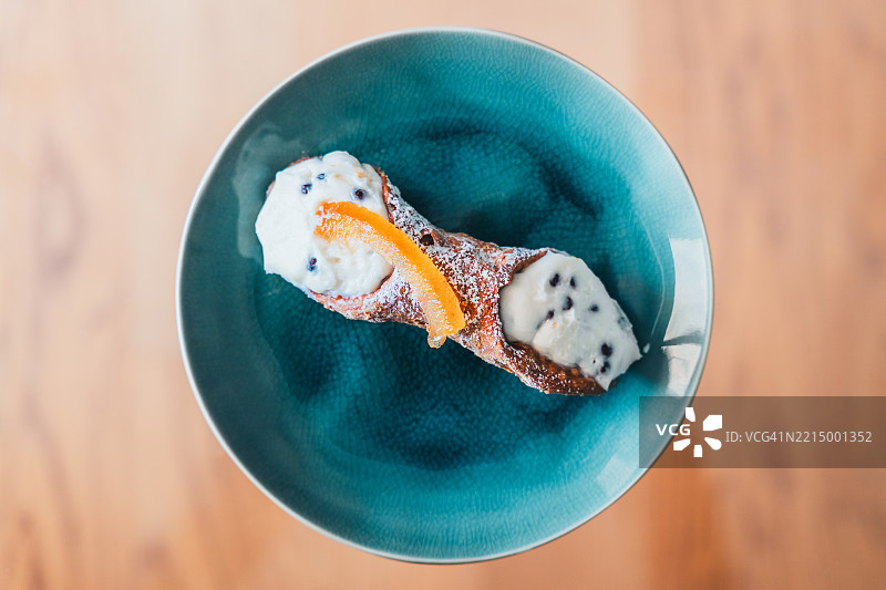 盘子上的卡农里，传统的西西里甜点，准备好享用。图片素材