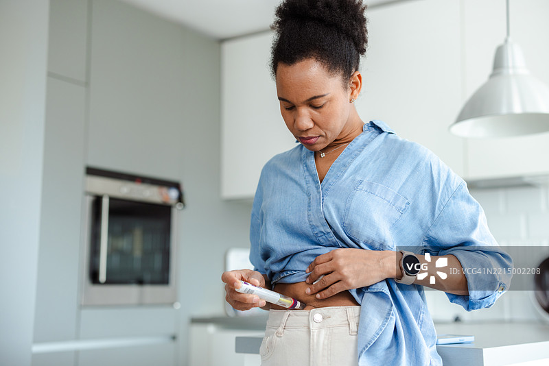 女性在明亮的现代厨房环境中给药图片素材
