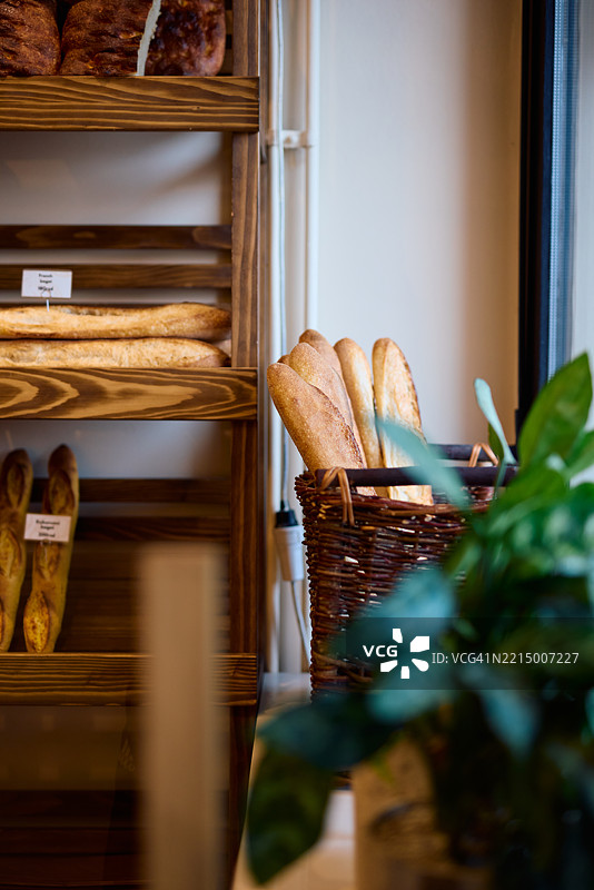 新鲜出炉的法棍面包在面包店的柳条篮中展示图片素材