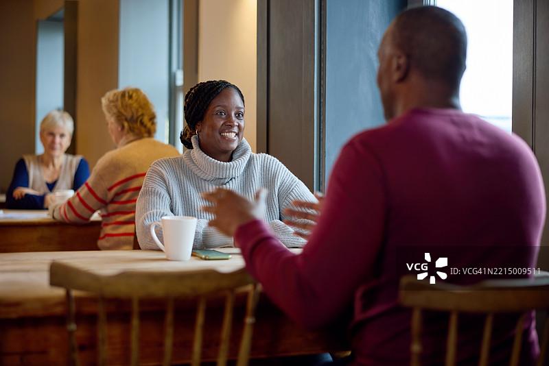 女性在餐厅的商务会议中倾听同事发言图片素材