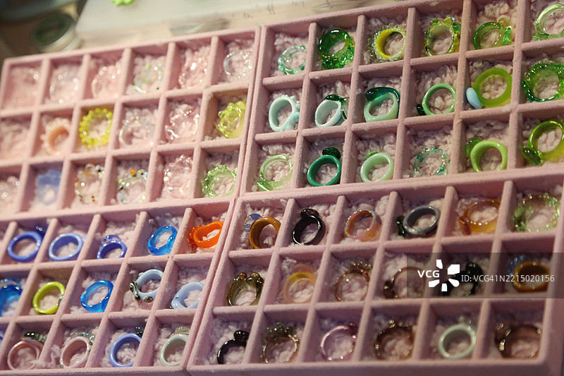 用回收材料制作的多彩塑料和石头戒指，准备在当地手工艺市场出售图片素材