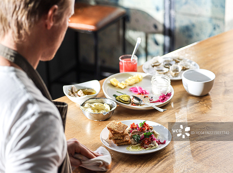 一位厨师在查看食材和成品菜肴图片素材