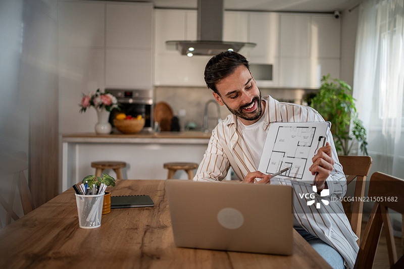 建筑师在家中视频通话时展示蓝图图片素材