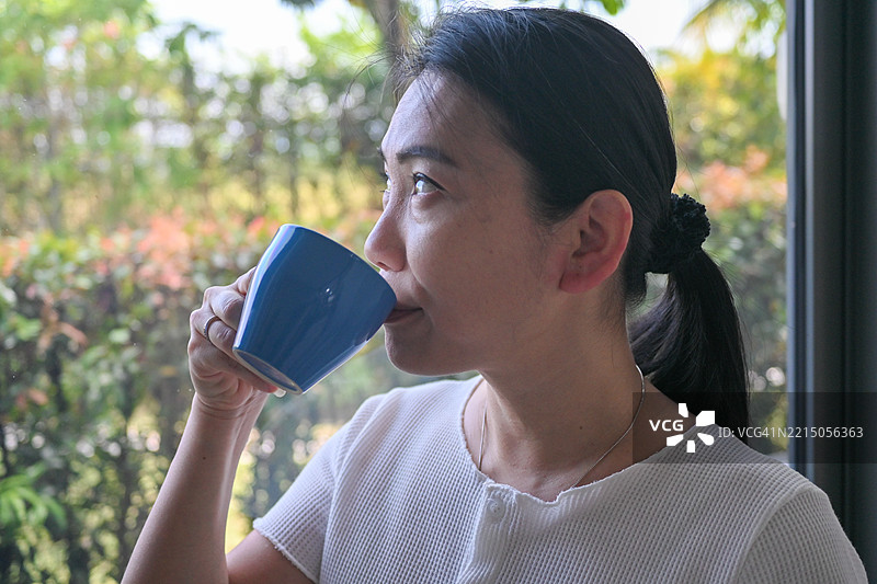 女人坐在窗边喝咖啡图片素材