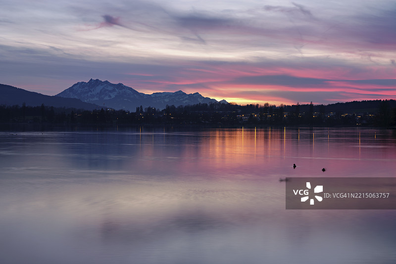 瑞士楚格州查姆的楚格湖傍晚氛围，背景是皮拉图斯山。图片素材