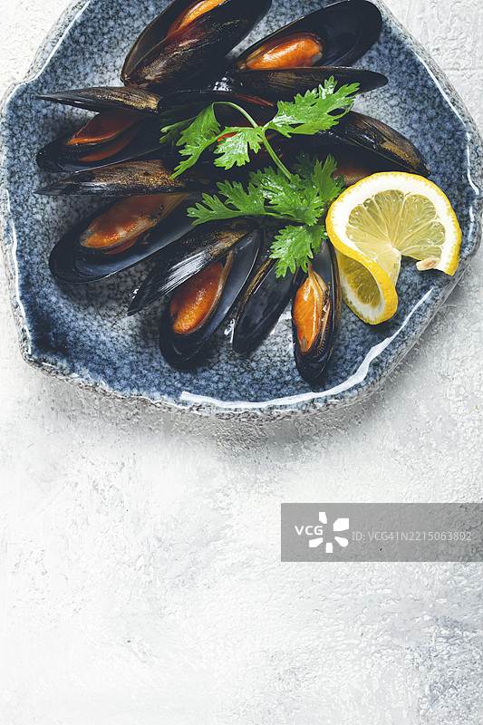 碗中盛着用自身汁液煮熟的贝类，灰色背景，俯视图，自制，无人。图片素材