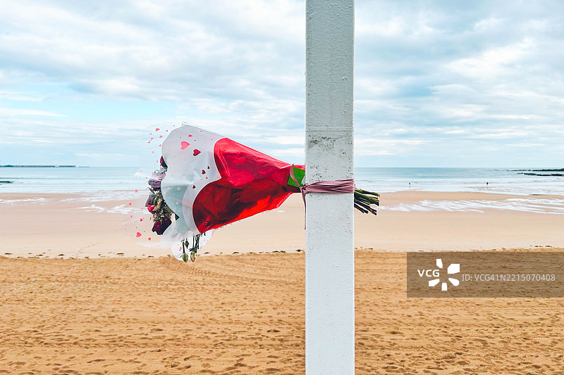 海滩前的柱子上绑着一束花束图片素材