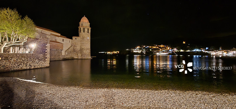 法国科利乌尔的夜景，灯光照亮的建筑和水面的倒影图片素材