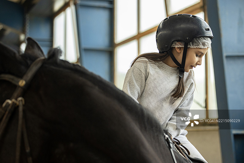 一个可爱的小女孩在牧场骑马图片素材