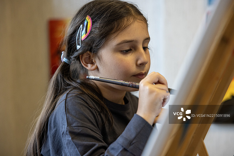 一个可爱的小女孩在艺术课上画画图片素材