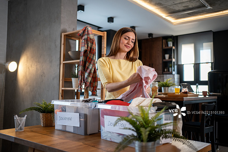 女性在家中整理衣物以捐赠图片素材