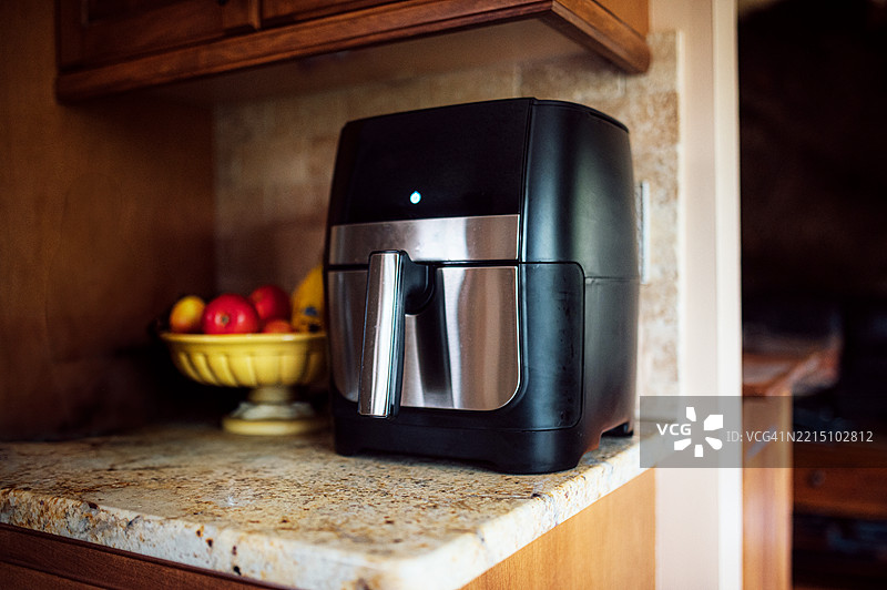 一个现代空气炸锅放在厨房台面上图片素材