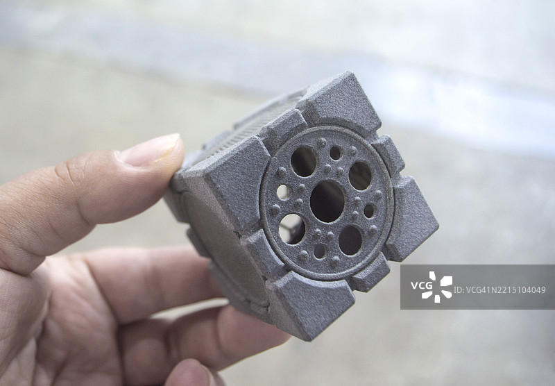 手中握着3D打印的塑料模型的人图片素材
