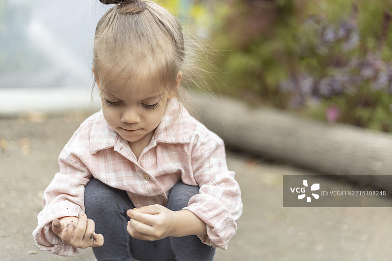 一个孩子的手握着一把泥土，正在玩耍的特写镜头图片素材