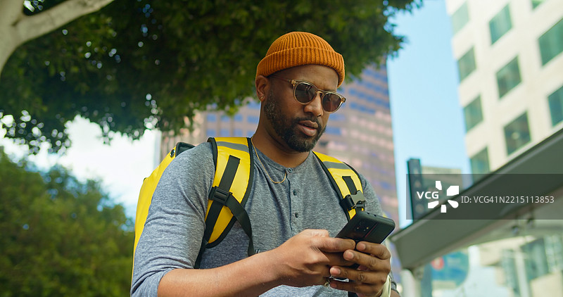 食品配送骑手查看手机 - 洛杉矶，加州图片素材