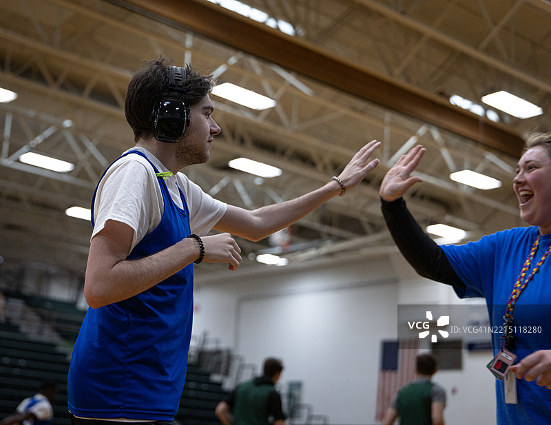 神经多样性男性与他的篮球教练击掌庆祝图片素材