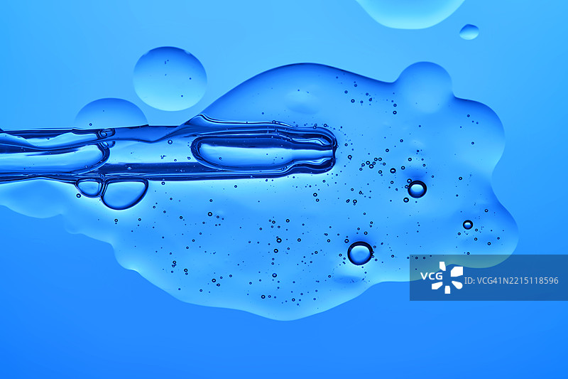 蓝色背景上的透明药水质感滴管图片素材