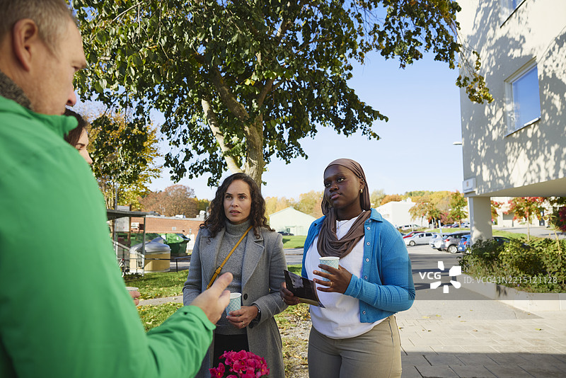 女性邻居在公园里聆听男性志愿者讲解慈善工作图片素材