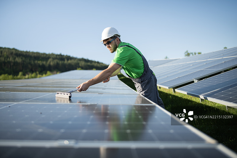 工人在清洁太阳能电池板。图片素材
