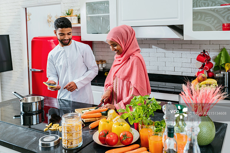 快乐的中东夫妇穿着传统阿拉伯服装在家中，阿拉伯联合酋长国图片素材