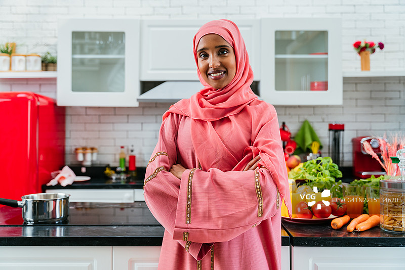 快乐而美丽的中东女性穿着传统阿拉伯服装在家中，阿拉伯联合酋长国图片素材