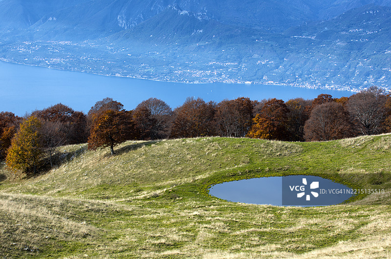 巴尔多山的高山牧场，背景是加尔达湖图片素材
