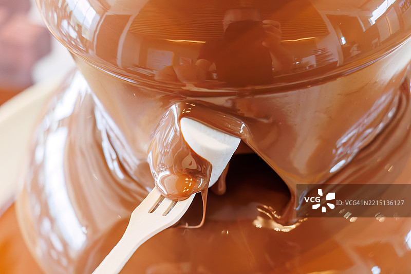 华丽的巧克力喷泉。自助餐厅。许多食物摆放在春天樱花的展示下。图片素材