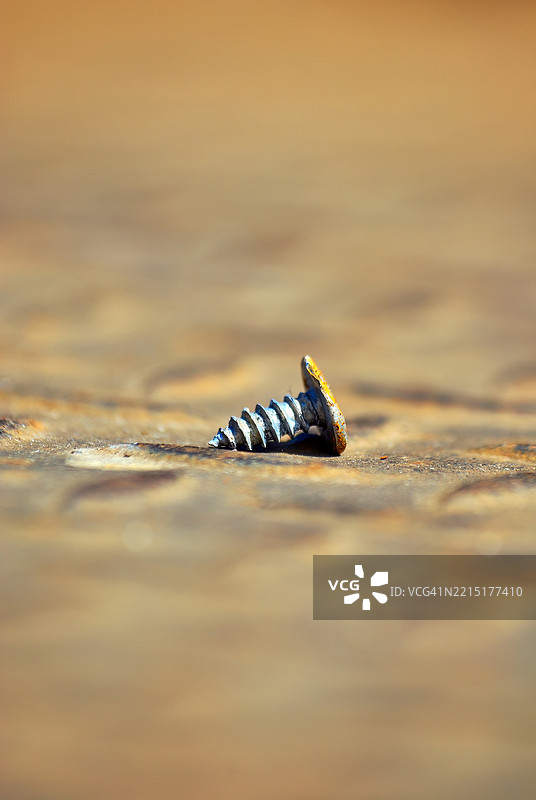 一颗生锈的旧螺丝钉，上面有一个凹痕。图片素材