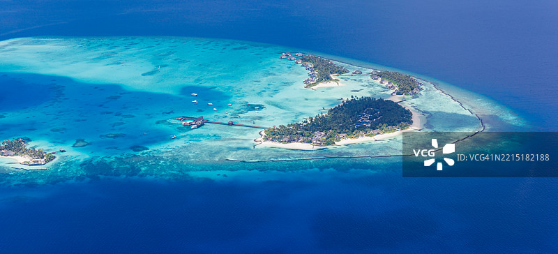 马尔代夫的空中视角，清澈的泻湖、洁白的沙滩和奢华的水上别墅。热带岛屿天堂和奢华度假胜地的逃离之地。图片素材