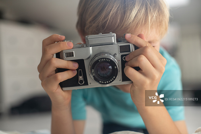 小男孩使用父亲的复古相机图片素材