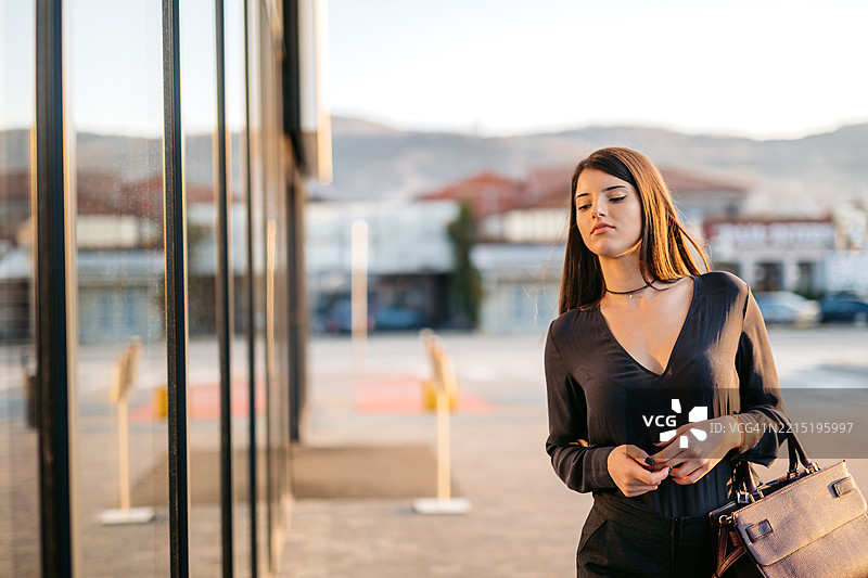 年轻女商人走进一座企业大楼图片素材